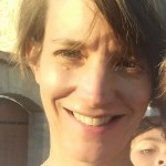 Author photo of Cécile Seiller: a closeup of her smiling widely in the bright sun, someone else's face just behind her under her left ear. Her hair slants across her left eye, darkened by shadow. 